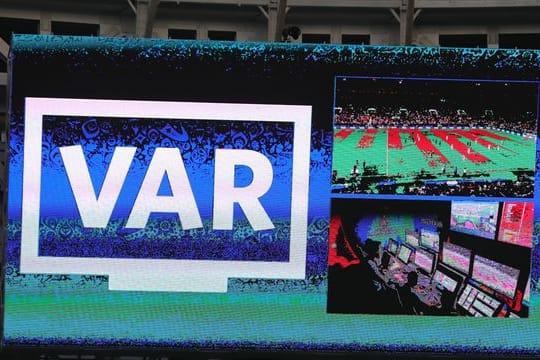 Auf der Anzeigetafel in einem Stadion ist der Schriftzug "VAR" für Video Assistent Referee zu sehen.
