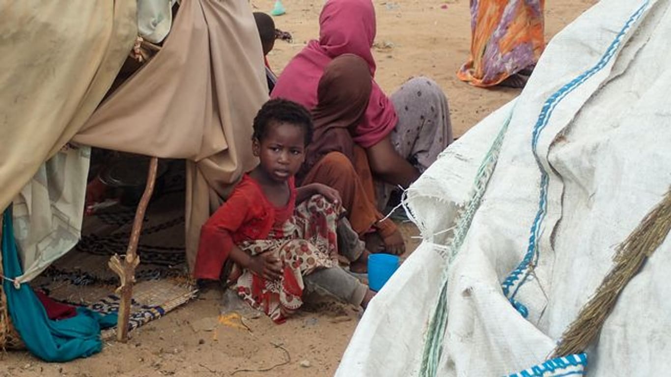 Von der Dürre betroffene Menschen sitzen vor einer Hütte im Lager für Binnenflüchtlinge Al-Hidaya am Rande von Mogadischu.