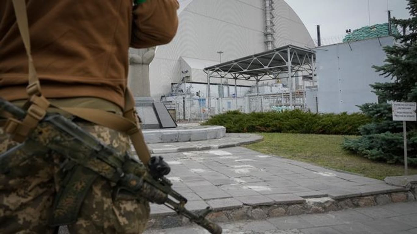Ein ukrainischer Soldat steht vor dem Sarkophag, der den explodierten Reaktor im Kernkraftwerk Tschernobyl abdeckt.