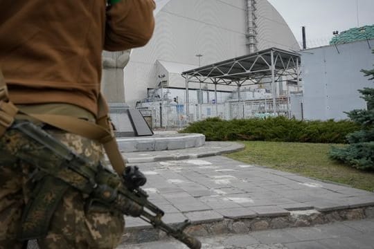 Ein ukrainischer Soldat steht vor dem Sarkophag, der den explodierten Reaktor im Kernkraftwerk Tschernobyl abdeckt.