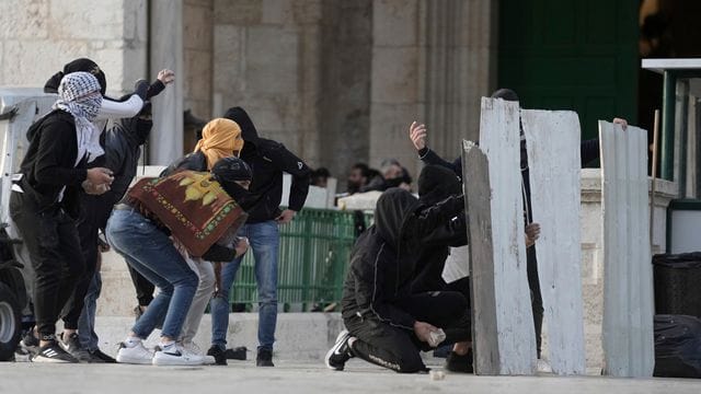 Palästinensische Demonstranten benutzen behelfsmäßige Schutzschilde bei Zusammenstößen mit der israelischen Polizei auf dem Gelände der Al-Aksa-Moschee in der Altstadt von Jerusalem.