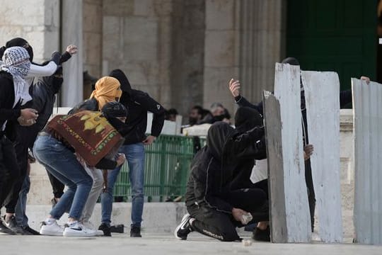 Palästinensische Demonstranten benutzen behelfsmäßige Schutzschilde bei Zusammenstößen mit der israelischen Polizei auf dem Gelände der Al-Aksa-Moschee in der Altstadt von Jerusalem.