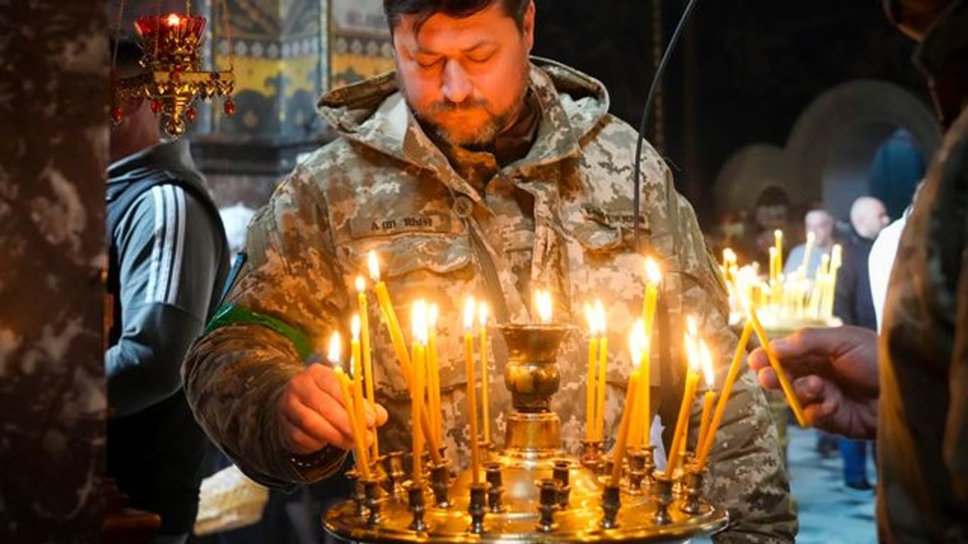 Ein ukrainischer Soldat entzündet Kerzen in der Wolodymyski-Kathedrale während der Osterfeierlichkeiten.