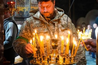Ein ukrainischer Soldat entzündet Kerzen in der Wolodymyski-Kathedrale während der Osterfeierlichkeiten.
