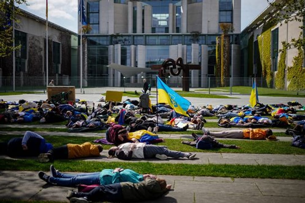 Auf dem Boden liegend protestieren diese Menschen vor dem Bundeskanzleramt gegen den Krieg in der Ukraine.