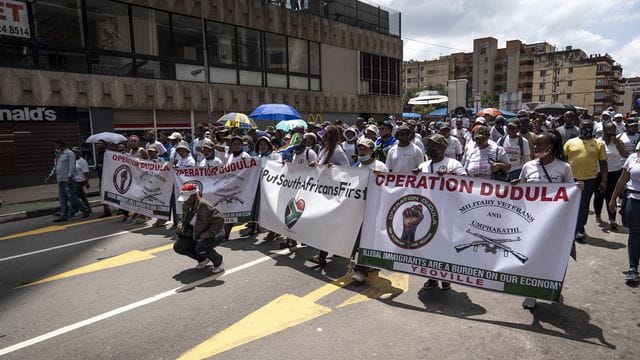 Mitglieder der "Operation Dudula" marschieren eine Straße im Stadtteil Hillbrow entlang um mehreren Unternehmen in der Gegend Memoranden zu übergeben.