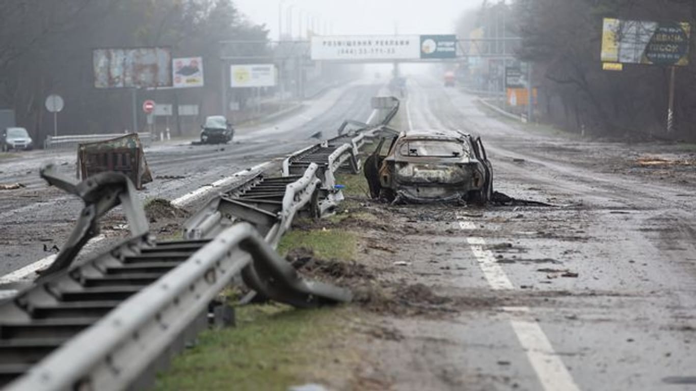 Ein zerstörtes Auto auf einer Landstraße bei Butscha.