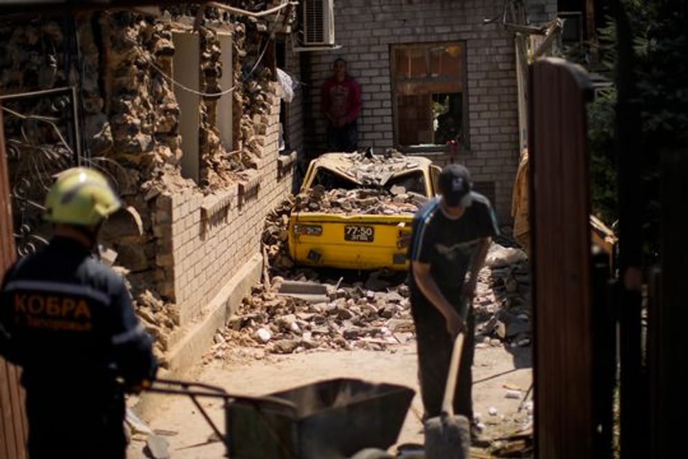 Rettungskräfte und Anwohner von Saporischschja entfernen Trümmer zerstörter Häuser.