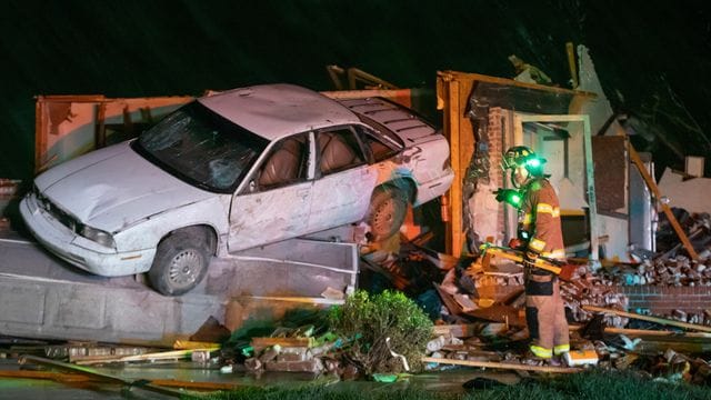 Ein Feuerwehrmann steht vor einem stark beschädigten Auto und Haus in Andover im Gebiet Kansas, nachdem ein Tornado durch das Gebiet östlich von Wichita gezogen ist. Ein Feuerwehrmann steht vor einem stark beschädigten Auto und Haus in Andover im Gebiet Kansas, nachdem ein Tornado durch das Gebiet östlich von Wichita gezogen ist.