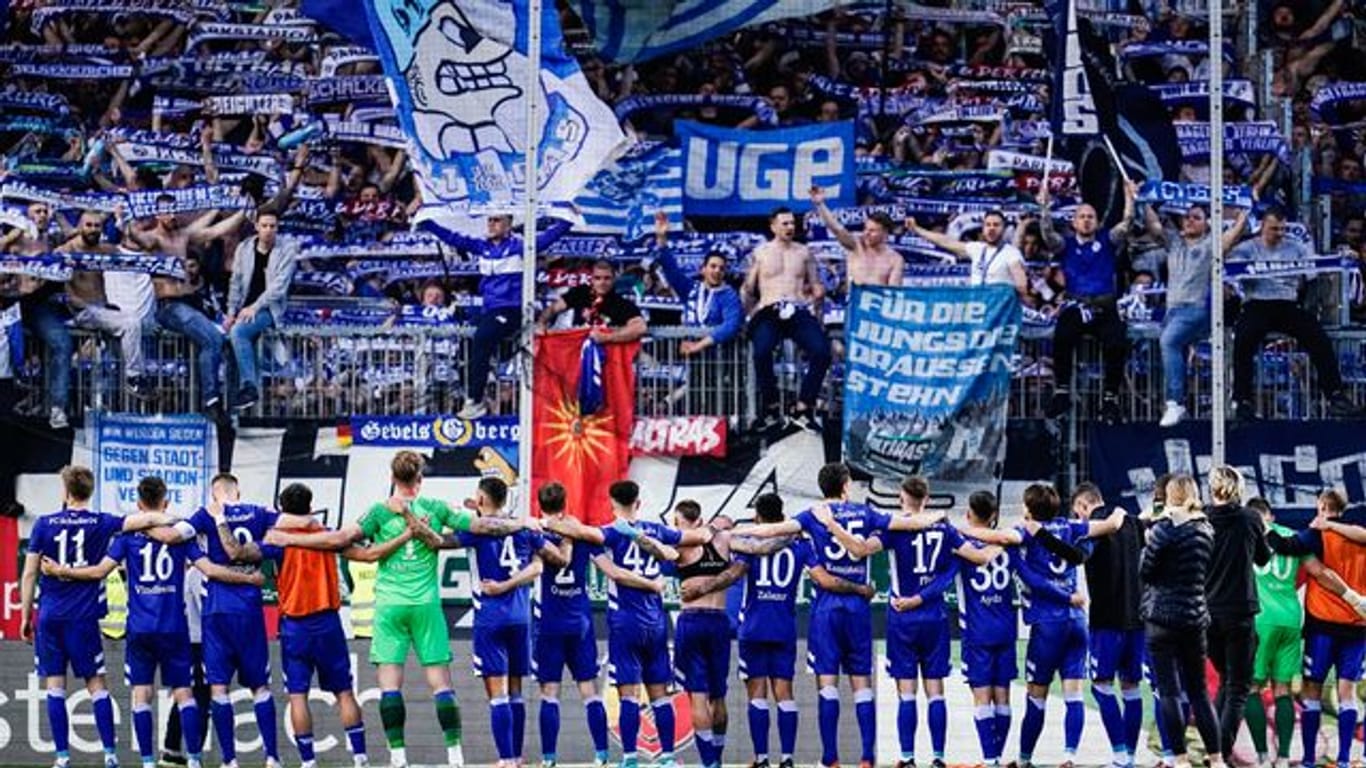 Die Spieler des FC Schalke 04 jubeln mit ihren mitgereisten Fans.