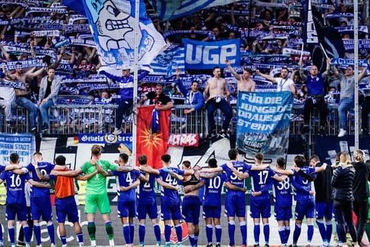 Die Spieler des FC Schalke 04 jubeln mit ihren mitgereisten Fans.