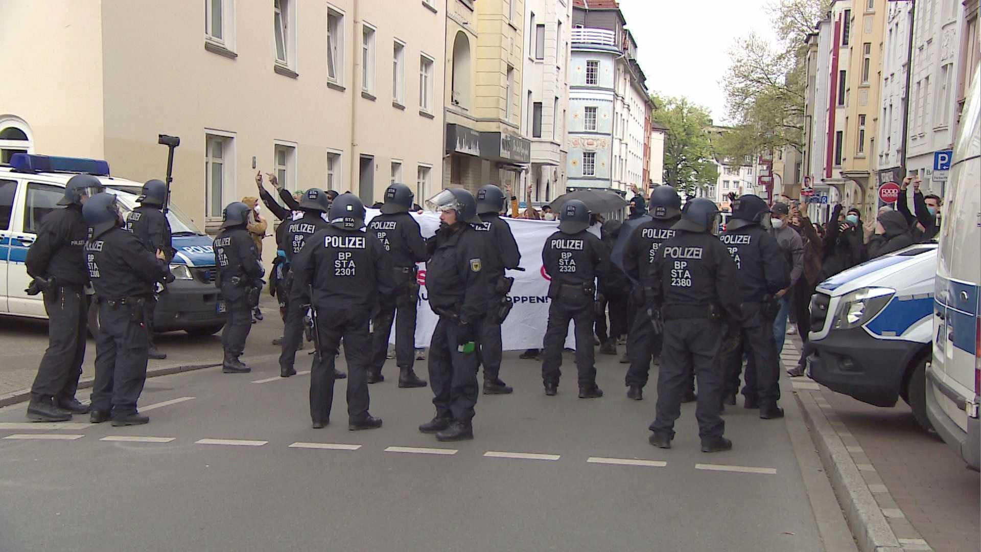 Polizisten stehen vor einem Banner der Demonstranten: Mehrere Personen wurden verletzt.