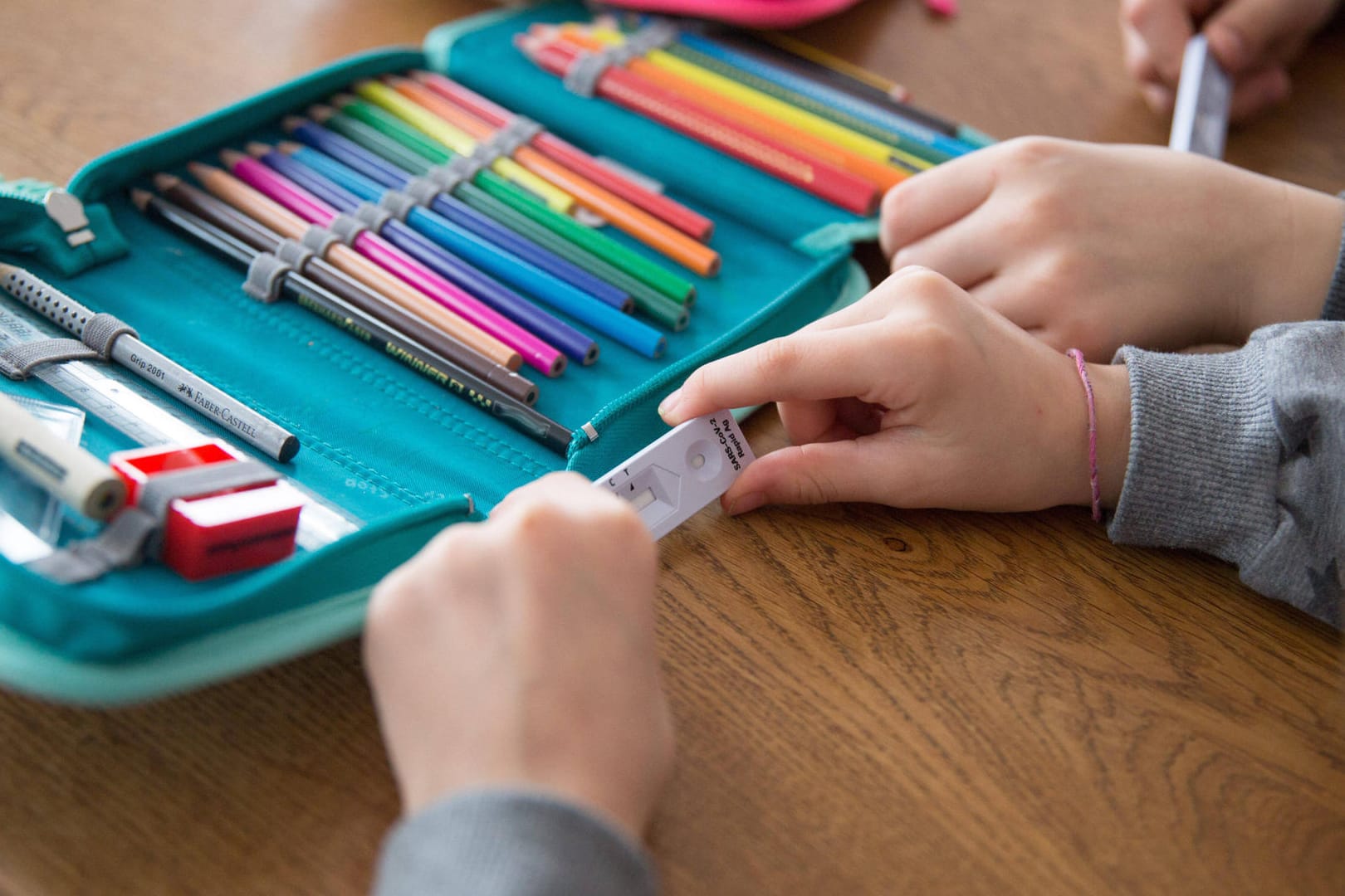 Kinder halten Corona-Schnelltest in der Hand (Symbolbild): In Niedersachsen entfällt die Testpflicht in Schulen und Kitas.