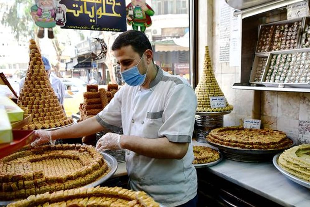 Ein Konditor arrangiert Baklava in einem Geschäft in Syrien.