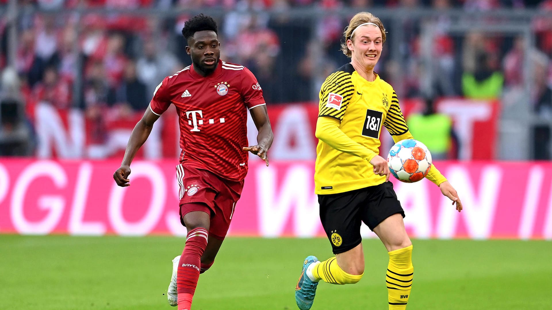 Zweikampf im Topspiel: Dortmunds Julian Brandt (r.) gegen Bayerns Alphonso Davies. Läuft bald wieder mehr Bundesliga-Fußball im frei empfangbaren TV?