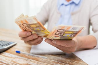Rentnerin zählt 50-Euro-Scheine (Symbolbild): Wer einkommensteuerpflichtig ist, soll im Sommer einen staatlichen Zuschuss von bis zu 300 Euro erhalten.