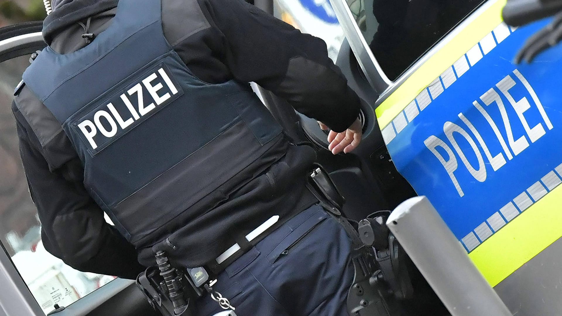 Ein Beamter der Polizei steht vor einem Einsatzfahrzeug (Symbolbild): Der Nachbar des Verstorbenen räumte ein, ihn getötet zu haben. Ein Beamter der Polizei steht vor einem Einsatzfahrzeug (Symbolbild): Der Nachbar des Verstorbenen räumte ein, ihn getötet zu haben.