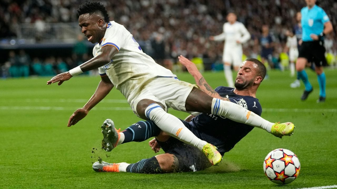 Vinicius Junior (l) von Real Madrid wird von Manchesters Kyle Walker gefoult.