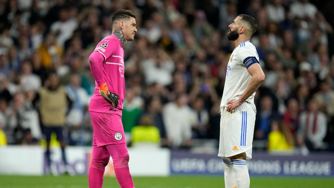 Kräftemessen vor dem Elfer: Manchesters Torhüter Ederson (l) und Karim Benzema.