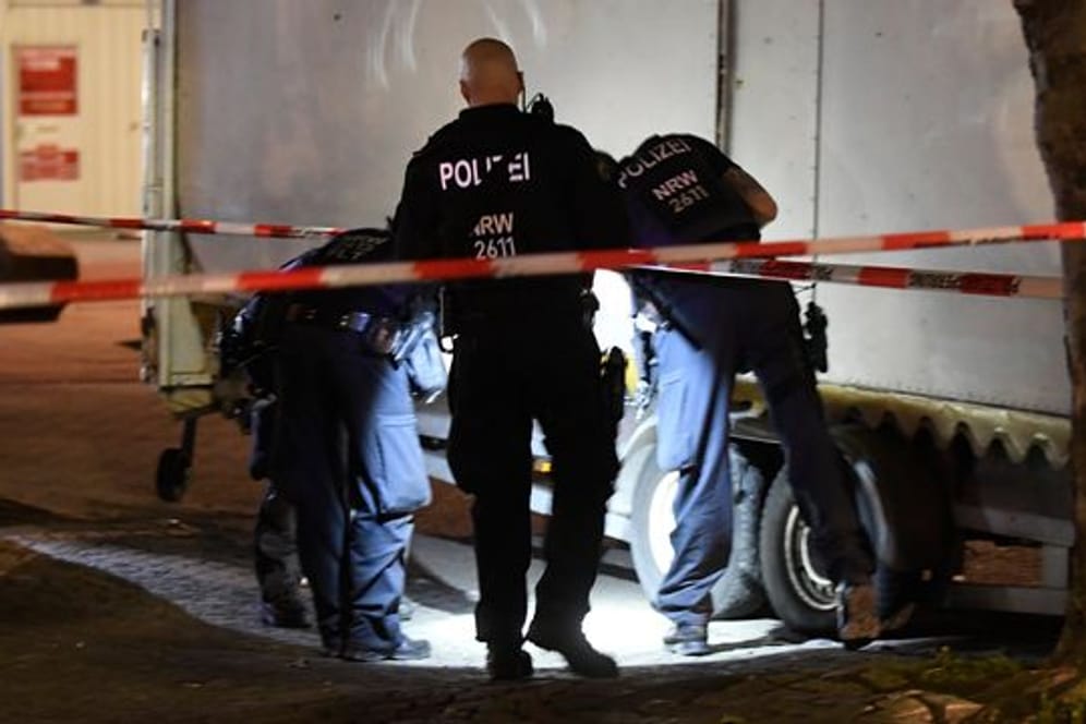 Polizisten suchen in der Nacht nach Spuren der Schiesserei auf dem Hamborner Altmarkt in Marxloh.