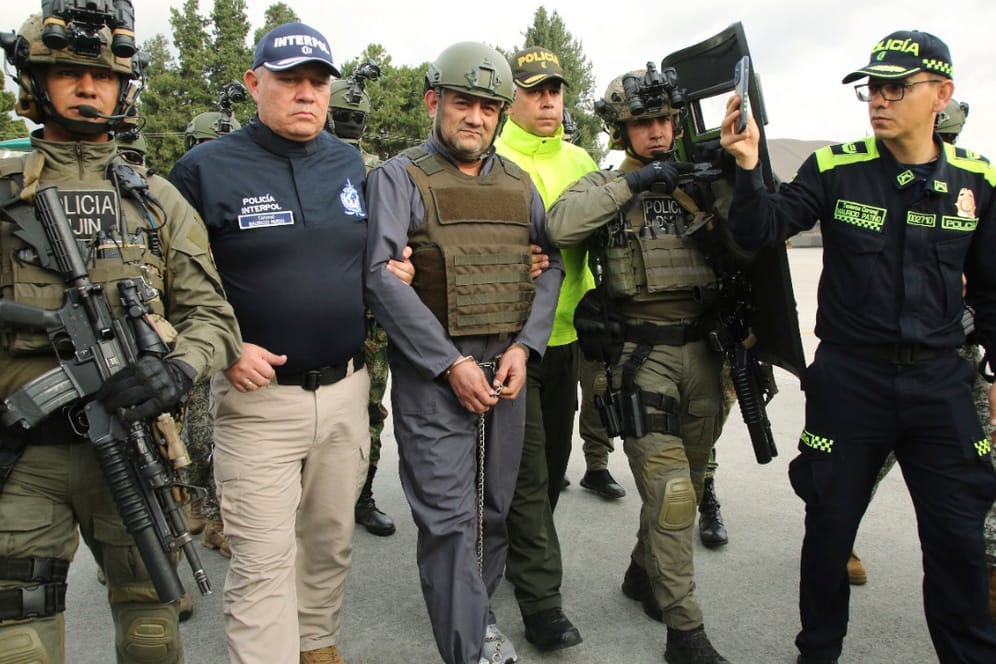 Die Polizei eskortiert Dairo Antonio Usuga (Mitte) auch bekannt als "Otoniel" auf einem Militärflughafen in Bogota: Der Drogenboss wurde an die USA ausgeliefert.