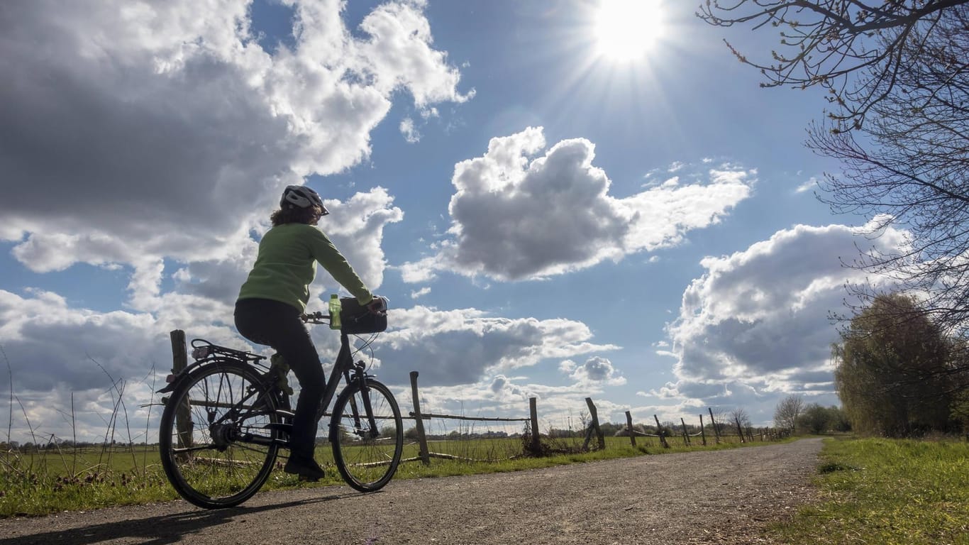 Eine Person auf einem Fahrrad bei Sonnenschein (Symbolbild): Berlin und Brandenburg erwartet heiteres Wetter.