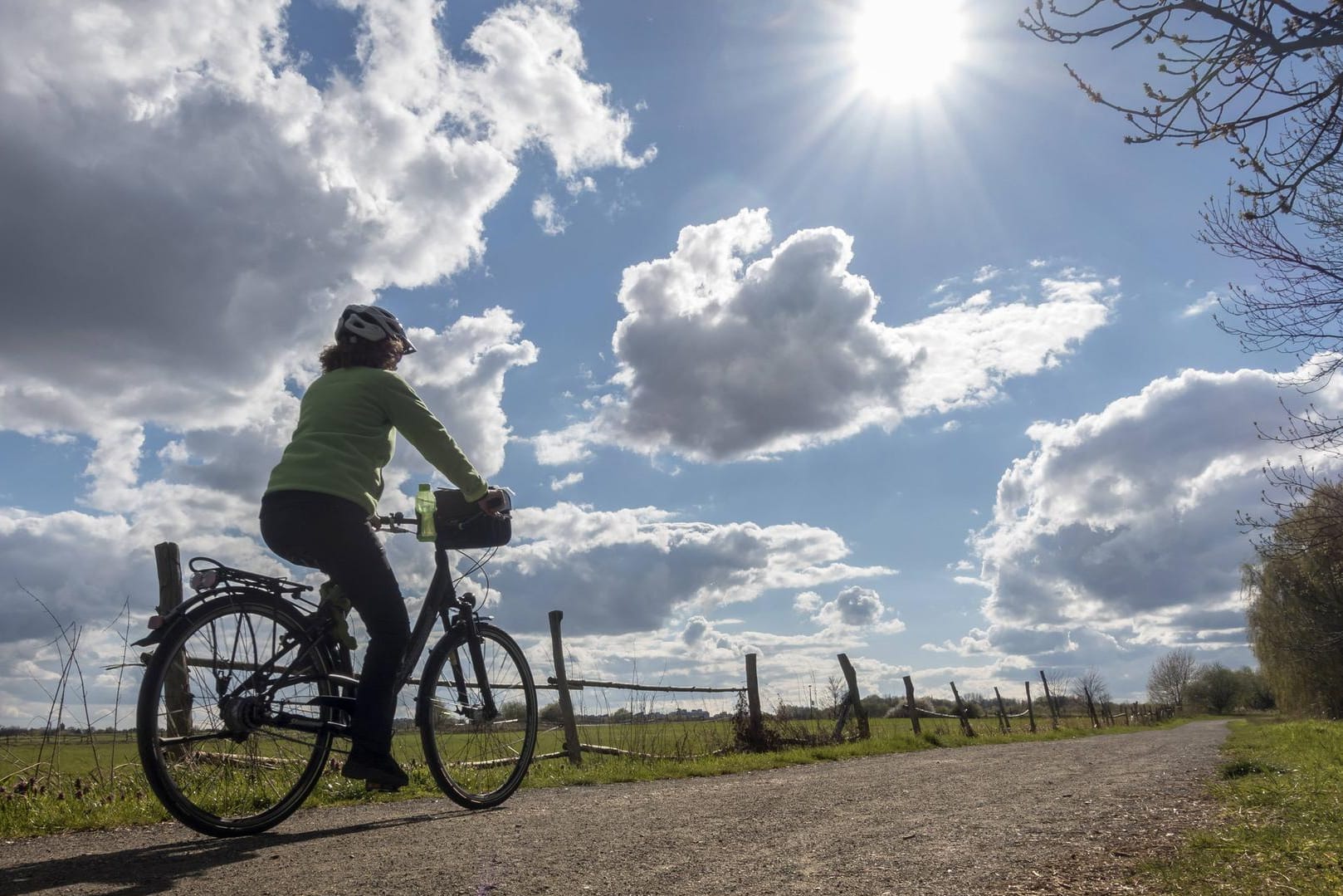 Eine Person auf einem Fahrrad bei Sonnenschein (Symbolbild): Berlin und Brandenburg erwartet heiteres Wetter.