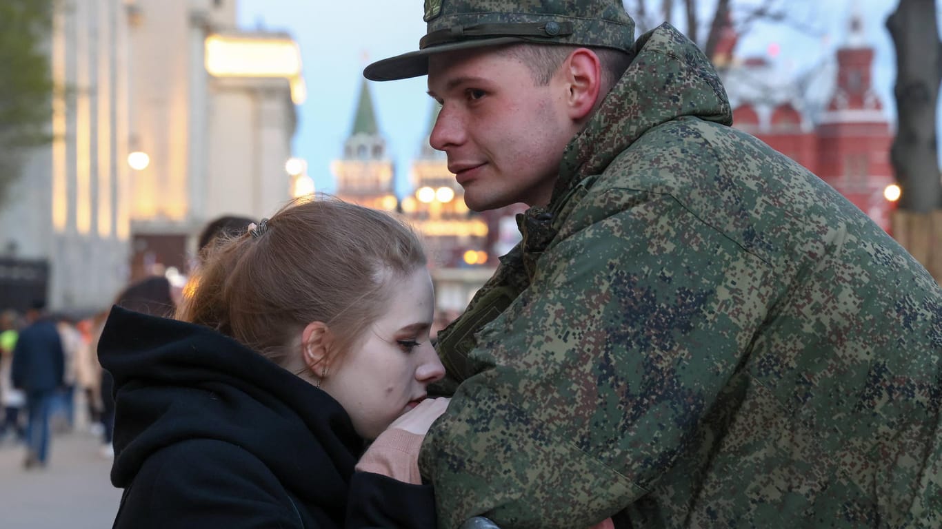 Eine junge Frau hält den Arm eines russischen Soldaten: Die Unzufriedenheit in der Bevölkerung könnte mit steigenden Verlusten innerhalb der Truppen wachsen.