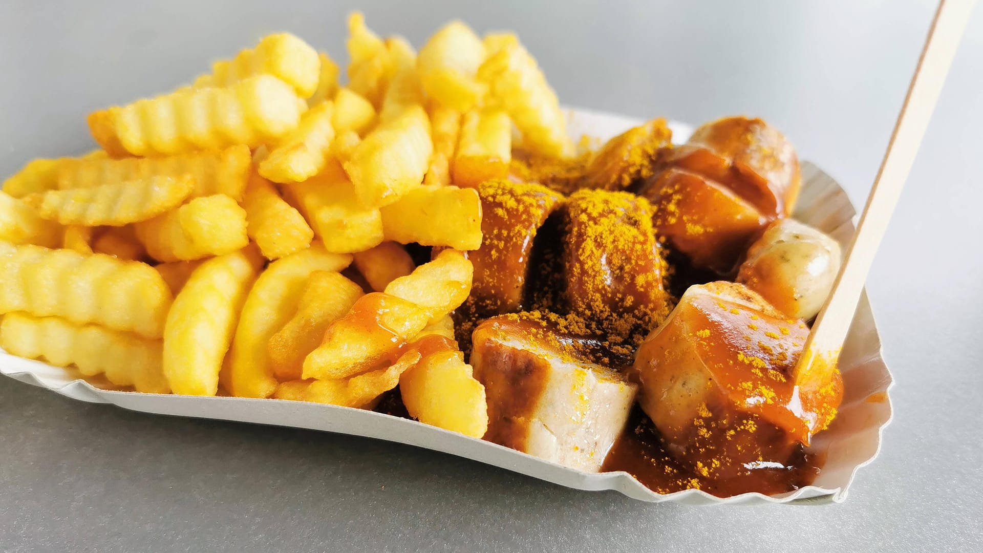 Eine Currywurst mit Pommes (Symbolbild): Fans und Imbissbetreiber spüren die Preissteigerungen.