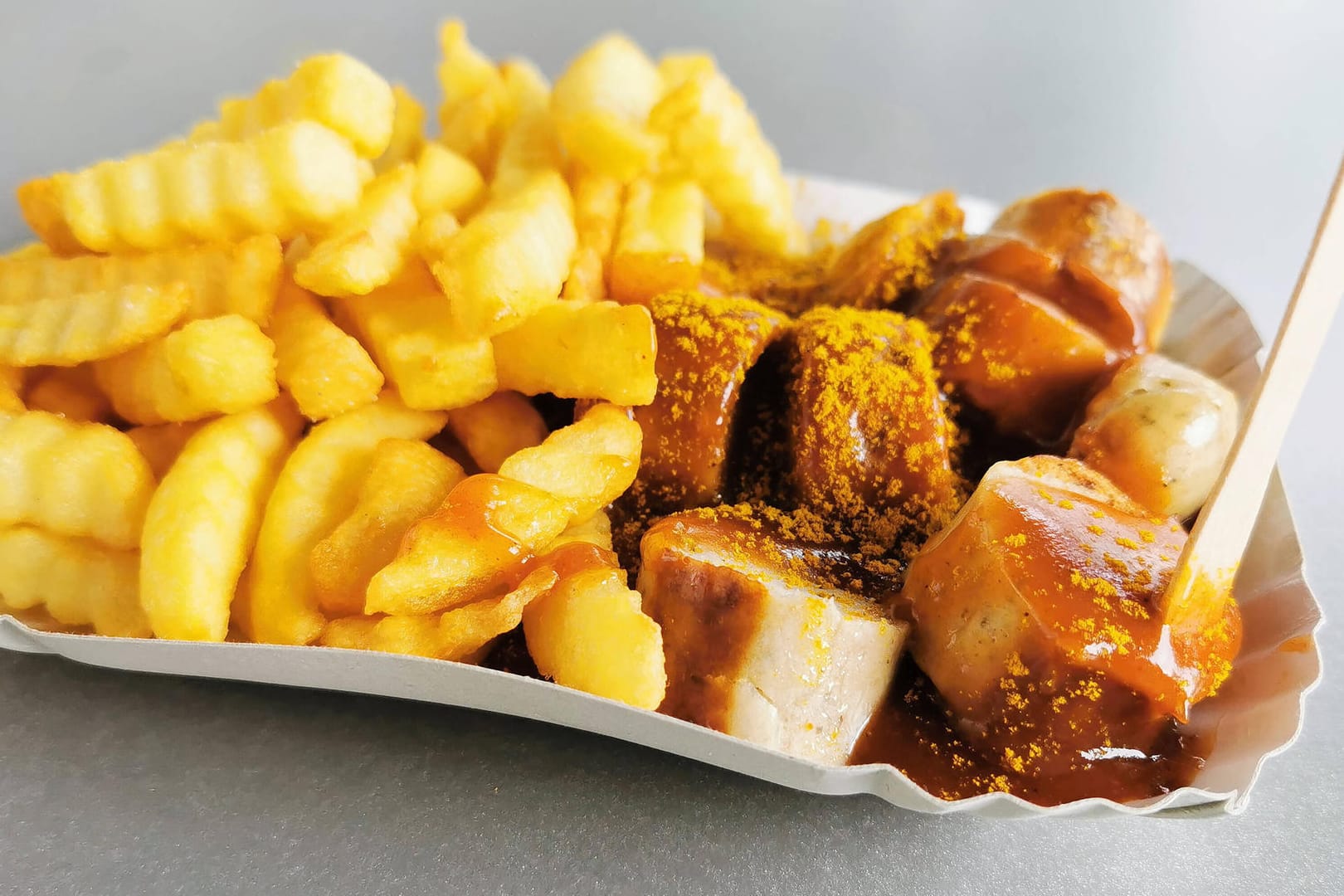 Eine Currywurst mit Pommes (Symbolbild): Fans und Imbissbetreiber spüren die Preissteigerungen.