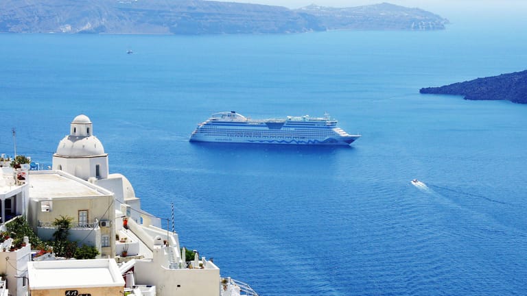 Die AIDAdiva vor Santorini: Die Passagiere können an Bord zahlreiche Traumziele auf der ganzen Welt bereisen.