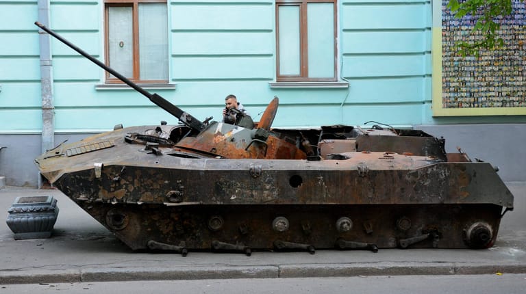Ein Ukrainer sitzt in einem zerstörten russischen Panzer: Auch Russland verzeichnet in der Ukraine massive Verluste.