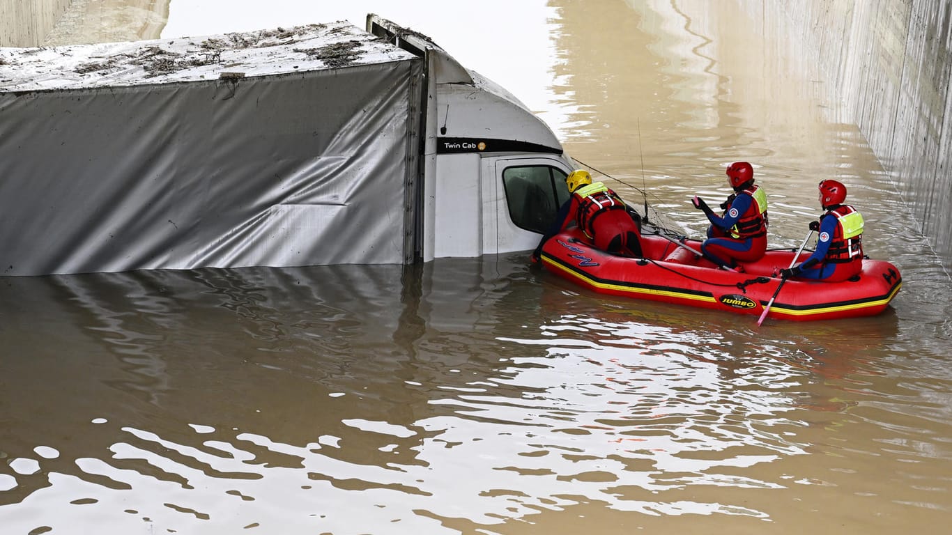 Einsatzkräfte blicken in den Kleinlaster in der überfluteten Unterführung in Saulgrub: Das Fahrzeug wurde am Donnerstagabend von den Wassermassen umschlossen.