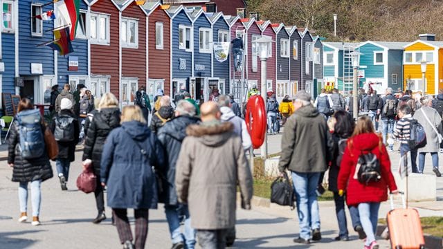 Helgoland-Besucher gehen nach ihrer Ankunft per Schiff über die Hafenstrasse Richtung Inselzentrum (Archivbild).