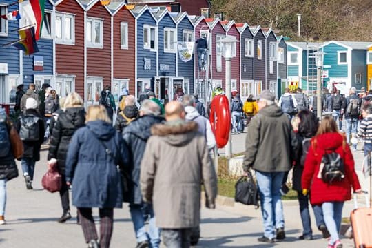 Helgoland-Besucher gehen nach ihrer Ankunft per Schiff über die Hafenstrasse Richtung Inselzentrum (Archivbild).