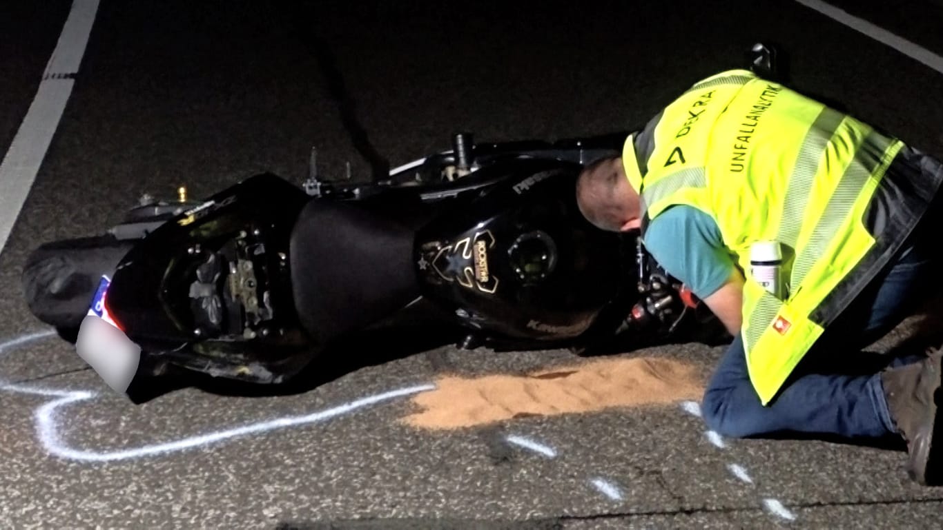 Ein Unfallgutachter arbeitet an einem verunglückten Motorrad. Der Motorradfahrer ist bei dem Unfall gestorben.