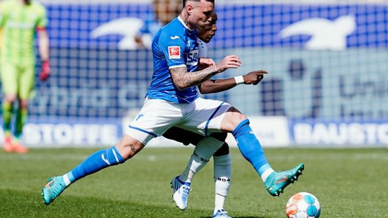 Fußball: Bundesliga, TSG Hoffenheims David Raum (vorne) und Leverkusens Moussa Diaby kämpfen um den Ball.