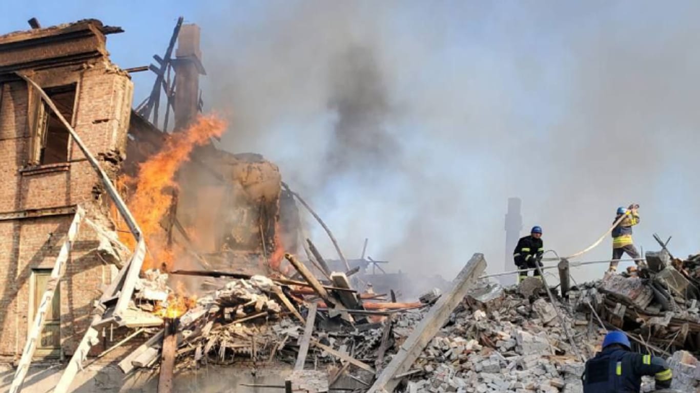 Feuerwehrleute löschen ein Feuer an einer zerbombten Schule nahe Lyssytschansk.