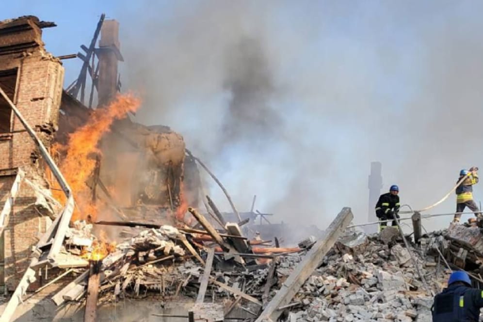 Feuerwehrleute löschen ein Feuer an einer zerbombten Schule nahe Lyssytschansk.