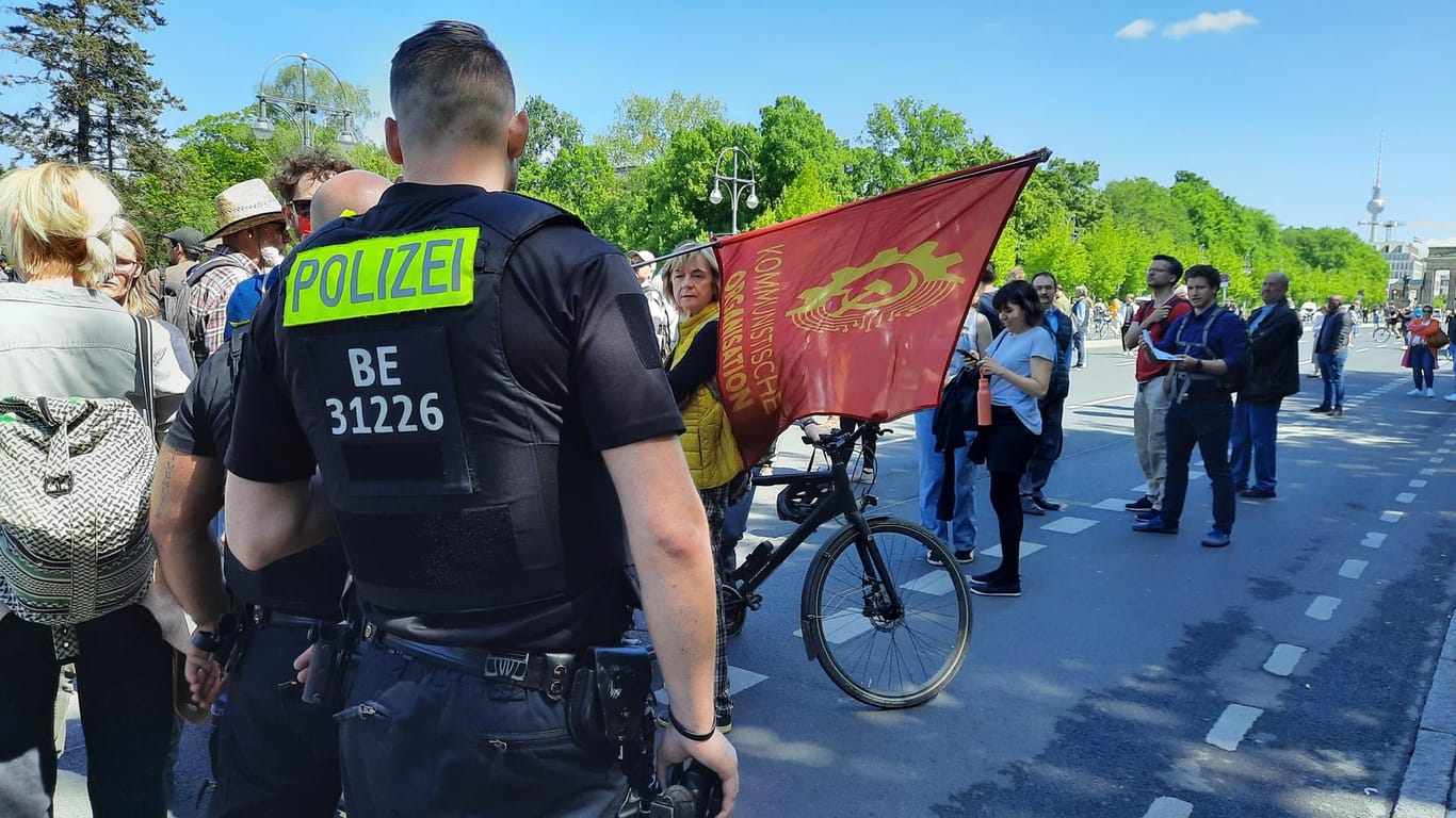 Ein Polizist geht auf Träger eines roten Banners zu: Die Flagge musste eingerollt werden.