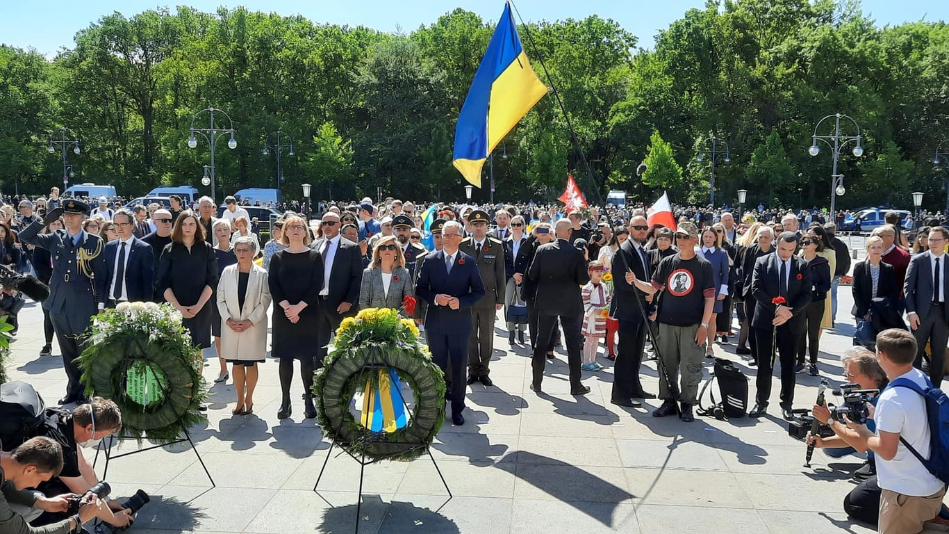 Der Ukrainsiche Botschafter mit seiner Frau und geladenen Gästern, im Hintergrund ist die Demonstration zu sehen: Am Sonntag kamen mehrere Hundert Leute zum Sowjetischen Ehrenmal im Tiergarten..