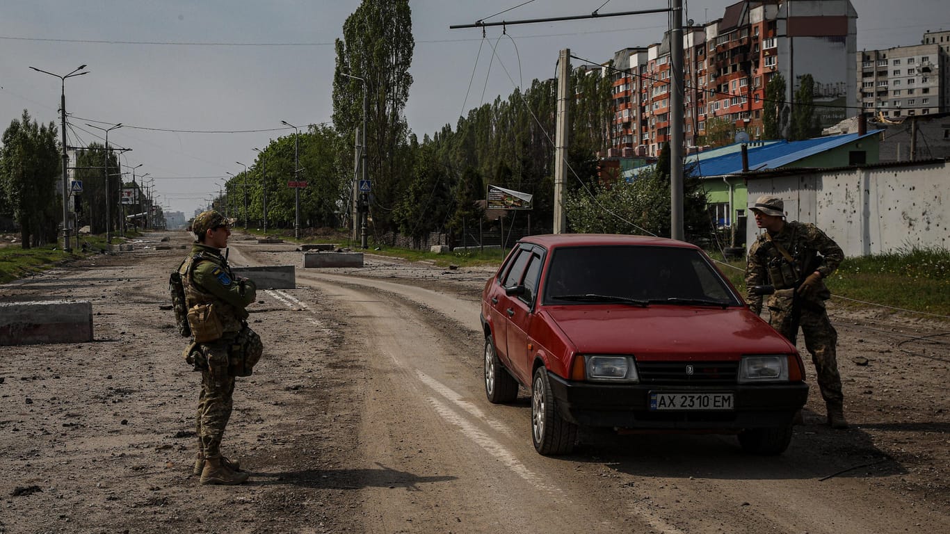 Schwer bewaffnete Soldaten überprüfen ein Auto in Charkiw.