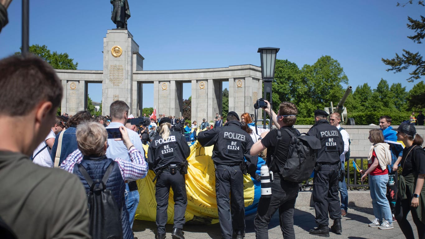 Polizisten rollen eine ukrainische Flagge ein(Archivbild): Bei den russischen Gedenkveranstaltungen in Berlin sind russische und ukrainische Fahnen verboten.