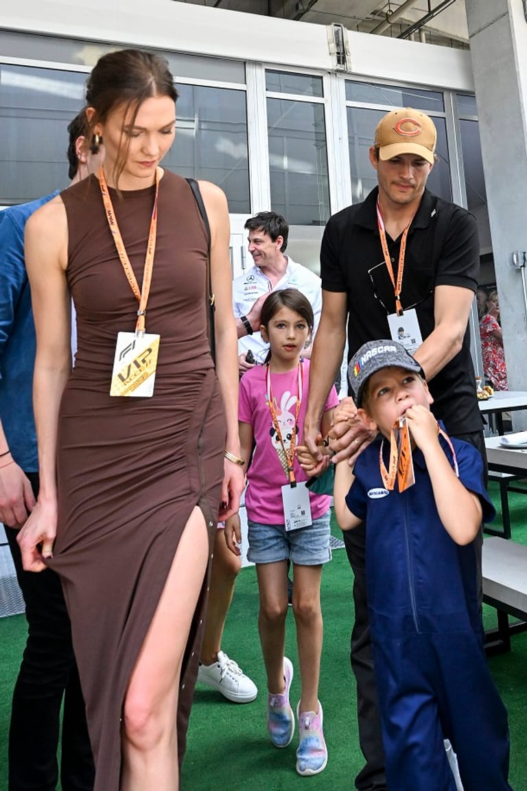 Ashton Kutcher hält seine beiden Kinder an der Hand.