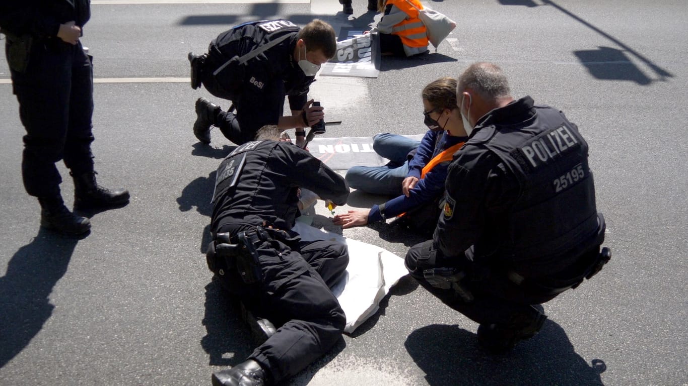 Polizisten beim Ablösen der Aktivisten: Drei Aktivisten blieben auf der Straße.