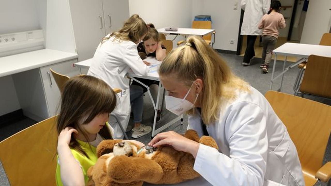 Nach der Wiedereröffnung des Teddybärkrankenhauses an der Universitätsmedizin empfängt Anna Rautmann, Medizinstudentin, den Teddy einer kleinen Besucherin.