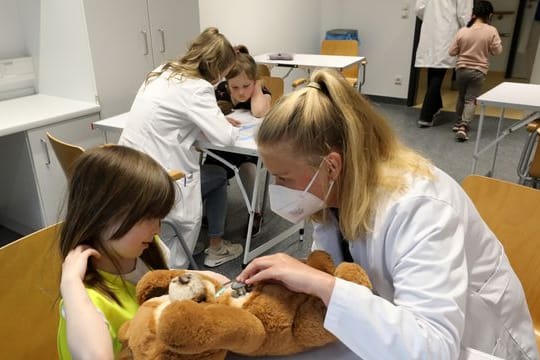 Nach der Wiedereröffnung des Teddybärkrankenhauses an der Universitätsmedizin empfängt Anna Rautmann, Medizinstudentin, den Teddy einer kleinen Besucherin.