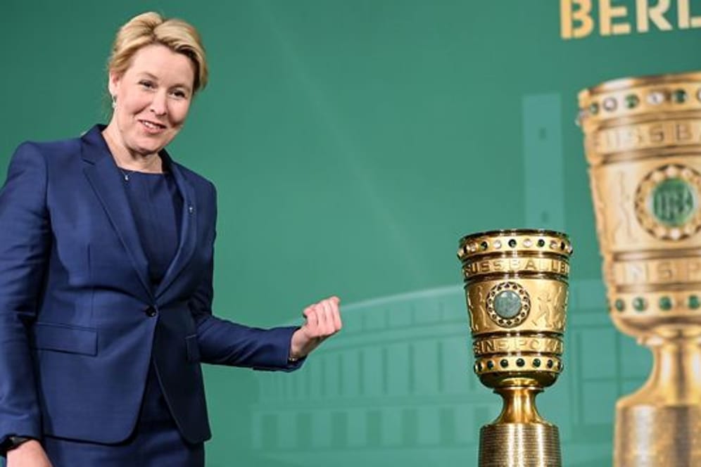 Berlins Regierende Bürgermeisterin Franziska Giffey (SPD) steht neben dem DFB-Pokal im Roten Rathaus.