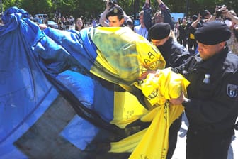 Polizisten rollen eine ukrainische Fahne ein: Die Bilder sorgten etwa beim ukrainischen Botschafter Melnyk für Empörung.