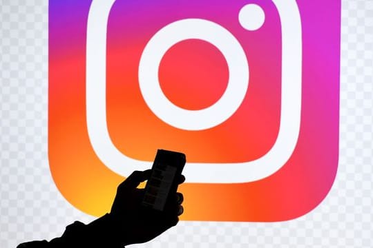 Ein Smartphone vor dem Logo von Instagram.